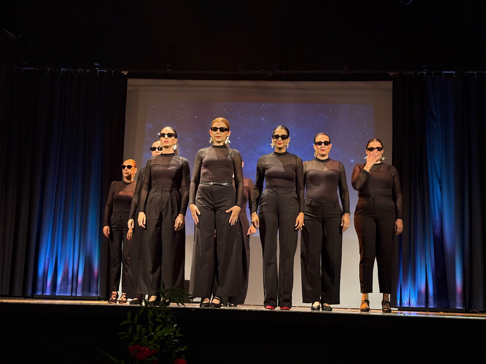 Tableau du spectacle, danseuses en noir et lunettes noires